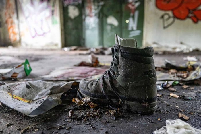 Ein einzelner Schuh, um den Schuh herum Müll