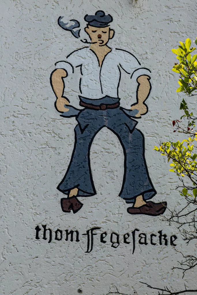 Wandbild eines Seemannes, darunter der Schriftzug "thom fegesacke"