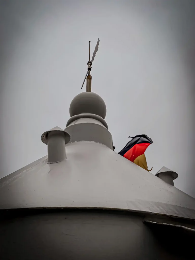 Spitze des Turmes mit einem kleinen Teil der Deutschlandflagge