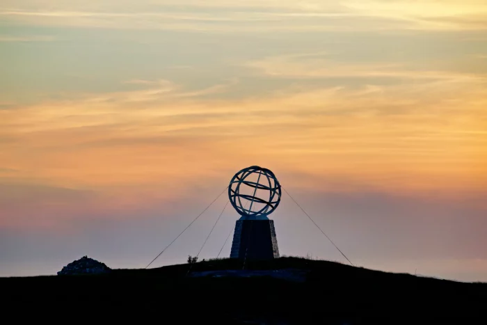 Silhouette der Globus-Skulptur am Polarkreis bei Sonnenuntergang