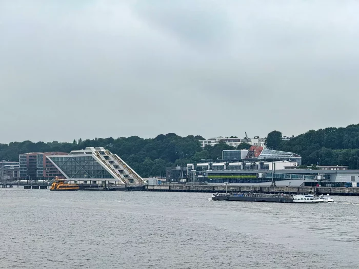 Mehrere Gebäude und ein Kreuzfahrtterminal. Schiffe auf dem Wasser