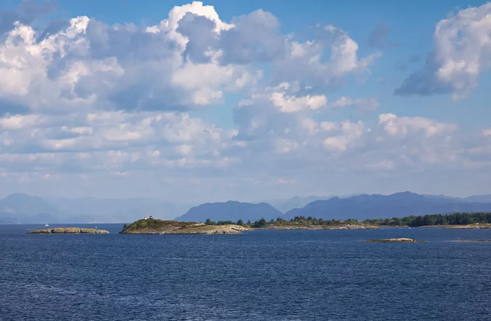 Kleine felsige Inseln im Meer unter bewölktem Himmel