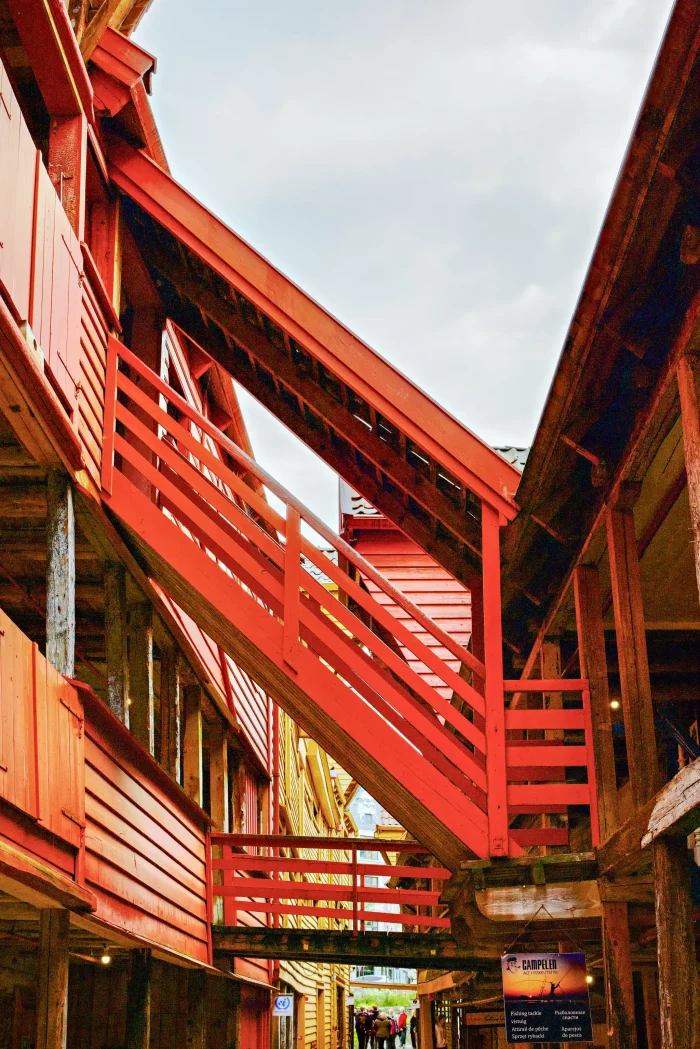 Rote Außentreppe zwischen traditionellen Holzhäusern in einem norwegischen Hafenort
