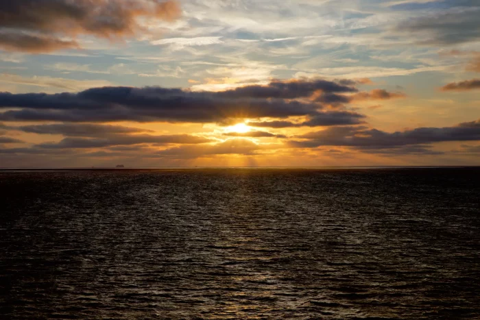 Sonnenuntergang über dem Meer mit Wolken am Himmel