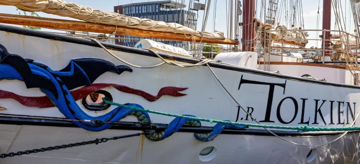 Bug des Segelschiffs J.R. Tolkien mit blauem Drachenmotiv und roten Wellenlinien am Rumpf