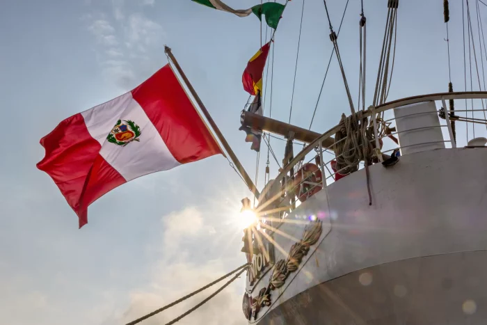 Peruanische Flagge weht am Heck eines Segelschiffs bei Sonnenuntergang