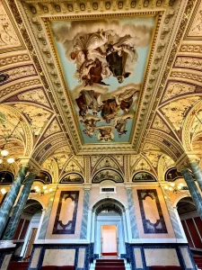 Deckenfresko mit Figurenmalerei im Foyer der Semperoper, umrahmt von goldenem Stuck.