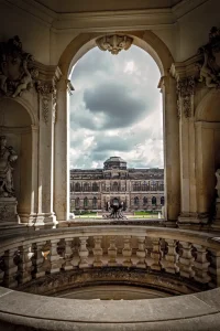 Ausblick durch Bogenfenster auf Zwinger-Galeriegebäude, Balustrade im Vordergrund.