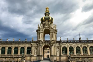 Kronentor des Zwingers frontal mit goldener Krone und Durchblick auf inneren Hof.